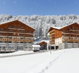 Façade de la résidence Les Chalets du Verdon à la Foux d'Allos en hiver avec neige