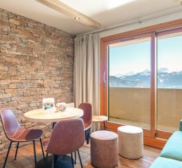 Séjour avec table à manger et canapé à Doucy dans la résidence Le Beauregard