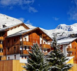 Résidence Les Etoiles d'Orion composée de batiments en bois et recouvert de neige