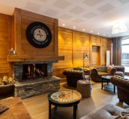 Common area with sofas and fireplace at the Les Chalets d’Émeraude residence in Les Saisies