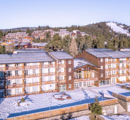 Extérieur de la résidence Pyrénées 2000 avec un montagne en arrière-plan sous la neige en hiver