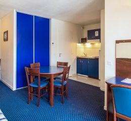 Séjour d’un appartement à Pyrénées 2000 composé d’une table à manger et d’une cuisine ouverte