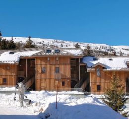 General view of the Résidence L’Orée des Pistes in winter under the snow