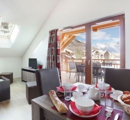 Salon avec fenêtre donnant sur les montagnes à la résidence Aquisana