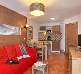 Séjour d’un appartement de la résidence Les Grand Lodge avec coin salon et espace salle à manger