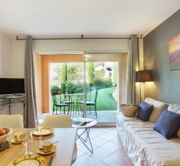 Living room with sofa and television in an apartment at La Licorne de Haute Provence