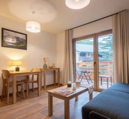 Living room with sofa and table in a studio apartment at the Arya Living Stone residence