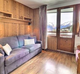 Salon avec canapé-lit et parquet en bois d’un appartement de la résidence Grand Bois à Courchevel La Tania