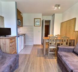 Overall view of the living room with lounge and dining area in the Grands Bois residence in La Tania Courchevel