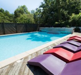 Horizontal view of the heated swimming pool at Les Collines Iduki with sun loungers