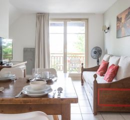 Salon ouvert sur un balcon avec TV et connexion internet dans les logements de la résidence Le Domaine du Rois à Bergheim