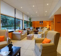 Lounge area with sofas at the reception of Résidence Les Roches Douvres