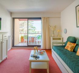 Living room with sofa and television in an apartment at Résidence du Golf