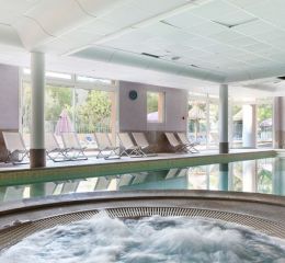 Relaxation area with hot tubs and indoor pool at the La Licorne de Haute-Provence residence in Gréoux-les-Bains.