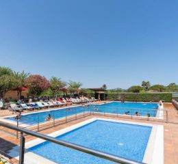 Large uncovered outdoor pool surrounded by sun loungers at Camping del Mar **** in Malgrat de Mar