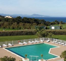 Wide view of the outdoor pool at the Ilbarritz residence with sea view