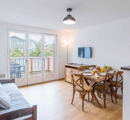 Salon équipé d'une télévision ouvert sur un espace extérieur d'un appartement aux Rives Marines au Teich