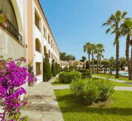 Bougainvillea-covered building with lush green gardens at the Sognu di Mare residence in Linguizzetta