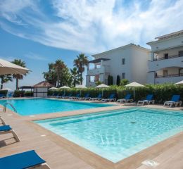 Central outdoor swimming pool and paddling pool with sun loungers at the Sognu Di Rena residence in Moriani-Plage