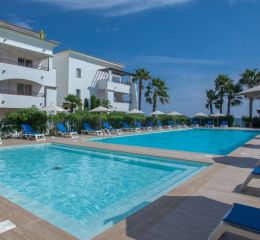 Central aquatic area accessible through the lush gardens of the Sognu Di Rena residence in Moriani-Plage