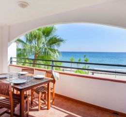 Open balcony with table and chairs and sea view in one of the apartments at the Sognu Di Rena residence in Moriani-Plage