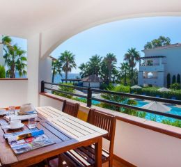 View of the swimming pool and the sea from the balcony of one of the apartments at the Sognu Di Rena residence in Moriani-Plage