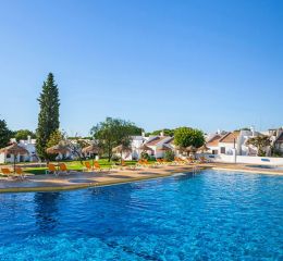 Large unheated outdoor swimming pool with sun loungers and a paddling pool area at Pedras da Rainha, Portugal