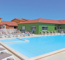 Heated outdoor swimming pool with sun loungers within La Grenadine residence in Marseillan-Plage