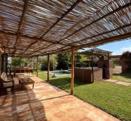 Grande terrasse ombragée avec mobilier de jardin ouverte sur le jardin clos à la Villa Dar Wellness