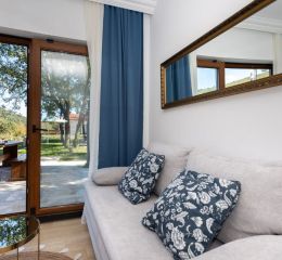 Living area of the Sveta Ana Lodges cottages opening onto a large wooden terrace sheltered from the sun