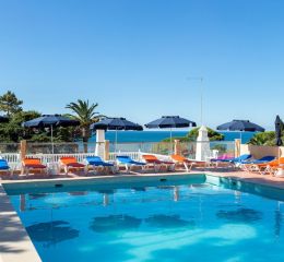 Swimming pool with sun loungers and deckchairs overlooking the sea at the Do Parque residence in Olhos d’Água