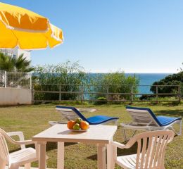 Terrace with outdoor furniture on the ground floor of the Do Parque residence in Olhos d’Água