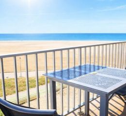 Balcony of a studio apartment with outdoor furniture and sea view at the Neptune residence.