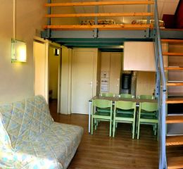 Living area of a cottage at Résidence Vorey-sur-Arzon with sofa bed, open-plan kitchen, and duplex layout