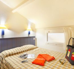 Bedroom with one double bed and two wall-mounted bedside lamps.