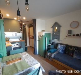 Salon ouvert sur une cuisine avec canapé lit gigogne dans les studios de Valfréjus