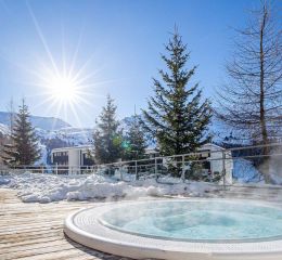 Espace bien-être en extérieur avec jacuzzi face aux montagnes de Flaine à la résidence Les Terrasses de Veret
