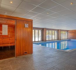 Indoor wellness area with a heated swimming pool and sauna at Les Terrasses de Veret Residence in Flaine