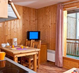 Les Chalets du Berger Residence – Living room with lounge area, fully equipped open-plan kitchen, and TV