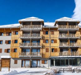 Façade de la résidence Aquisana à Serre Chevalier l'hiver sous la neige