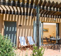 Salon avec tomettes au sol et vue sur le golf d’un logement au Provence Country Club