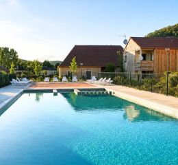 Piscine extérieure de la résidence le clos du rocher avec des transats