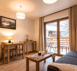 Living room with sofa and table in a studio apartment at the Arya Living Stone residence