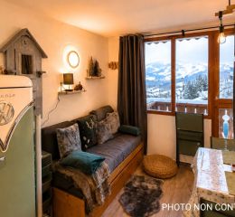 Salon ouvert sur une cuisine avec canapé lit gigogne dans les studios de Valfréjus