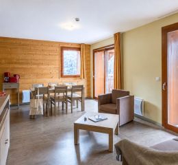 Salle à manger ouverte sur un balcon avec vue sur les monts dans les appartements Les Epinettes à Vaujany