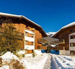 Extérieur des chalets enneigés aux Fermes de Samoëns en Haute Savoie