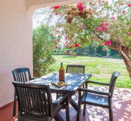 Terrasse privative donnant sur les jardins de la résidence Pedras del Rei au Portugal avec salon de jardin