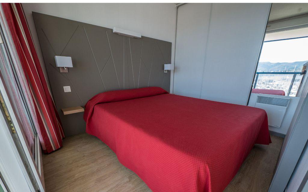Slide Bedroom with a double bed, wardrobe, and view of the port of Hendaye